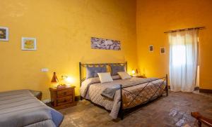 1 dormitorio con cama y pared amarilla en Palatium Le Caselle, en Viterbo