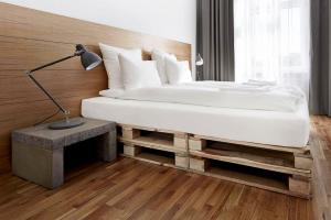 a bedroom with a large bed with a lamp on a table at CityNest Apartments in Kraków