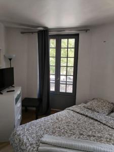 a bedroom with a bed and a window at Studio Saint-Jacques in Paris