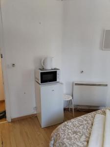 Una sala de estar con un sofá y un microondas. en Studio Saint-Jacques, en París