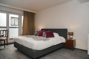 a bedroom with a bed with red pillows on it at Villa Yvonne in Ostend