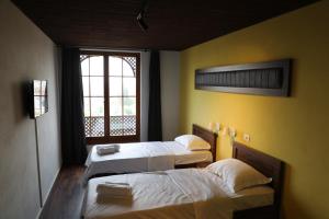 a room with two beds and a window at Hotel Hiserra in Prizren