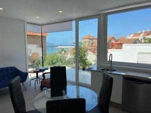 a kitchen and living room with a view of the ocean at PASEO MARÍTIMO PANXON in Nigrán