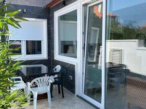 a patio with a table and chairs and glass doors at PASEO MARÍTIMO PANXON in Nigrán