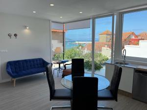 a living room with a table and chairs and a large window at PASEO MARÍTIMO PANXON in Nigrán
