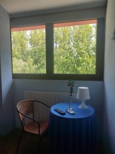 una mesa azul con una lámpara y una ventana en HOTEL PASTERAL RIU TER, en La Cellera de Ter