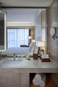 a bathroom with a sink and a large mirror at Courtyard by Marriott Hangzhou Qianjiang in Hangzhou