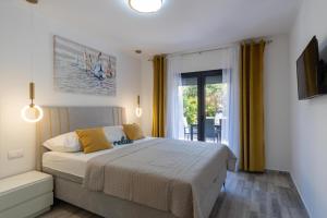 a bedroom with a bed and a large window at Apartmani PARDON in Pag