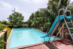 una piscina con scivolo accanto a una casa di Loft Sole by Wonderful Italy a Giarre
