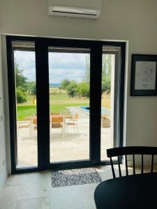 an open glass door with a view of a patio at Logement B / Clos des Saunières in Bligny-lès-Beaune