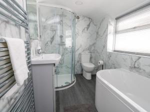 a bathroom with a tub and a sink and a toilet at Day Cottage in Weymouth +32 photos