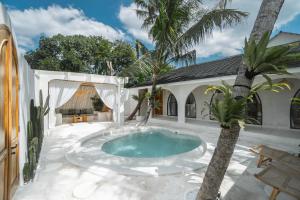 einen Pool auf einer Terrasse mit einer Palme in der Unterkunft Bohemian Jogja Villas with Private Pool in Kejayan