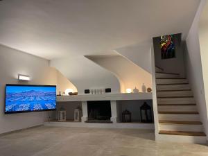 a living room with a staircase and a large screen tv at Villa Ormarine, vue exceptionnelle sur la baie de Cannes et le Mercantour in Les Adrets de l'Esterel