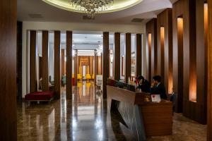 a lobby with two people sitting at a reception desk at Parwar Hotel in Duhok +101 photos