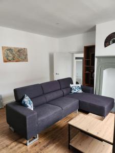 ein Wohnzimmer mit einem blauen Sofa und einem Couchtisch in der Unterkunft la maison de Léa in La Bachellerie