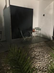 a large screen in a room with a table and chairs at Casa Penina in Portimão