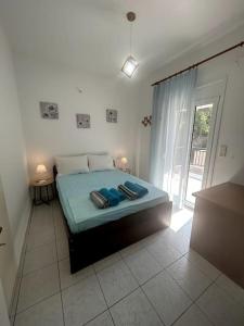 a bedroom with a bed with blue sheets and a window at Our Home in Heraklio