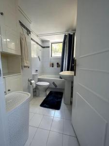 a bathroom with a tub and a toilet and a sink at Our Home in Heraklio