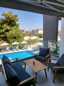 a patio with chairs and a table and a pool at Evion Residence A11 in Nikiti