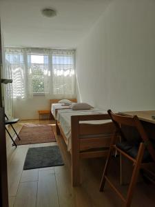 um quarto com 2 camas, uma secretária e uma cadeira em TETA NEDA em Omiš