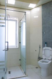 a bathroom with a toilet and a glass shower stall at Old City Apartment in Baku