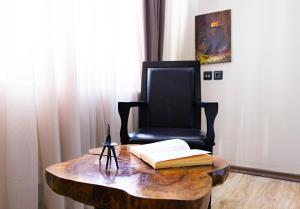 a wooden table with a chair and a book on it at Old City Apartment in Baku