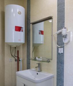 ein Badezimmer mit einem weißen Waschbecken und einem Spiegel in der Unterkunft Old City Apartment in Baku