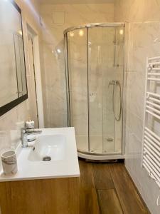 La salle de bains blanche est pourvue d'une douche et d'un lavabo. dans l'établissement Cité Gastro. / Centre Ville, à Dijon