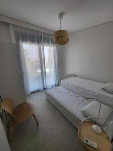 a bedroom with a bed and a chair and a window at Evion Residence A11 in Nikiti +10 photos