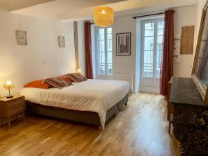 a bedroom with a bed and two windows at Cité Gastro. / Centre Ville in Dijon