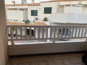 un balcone con ringhiera bianca e un edificio di La Perla Negra en Cabo de Palos a Cabo de Palos