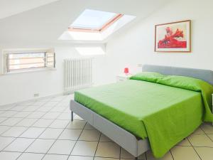 a bedroom with a bed with a green blanket at Homiday - BordoPineta Centro in Pineto