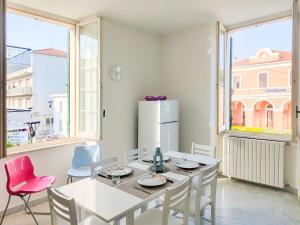 a dining room with a white table and chairs at Homiday - BordoPineta Centro in Pineto
