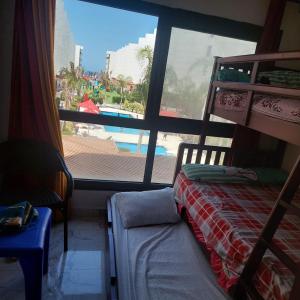 een slaapkamer met een bed en uitzicht op een zwembad bij Porto Said Star شاليةمتكامل ثلاث ججرات ماستر ومطبخ ورسبشن دور أول على بحر وبسين in `Ezbet Shalabi el-Rûdi