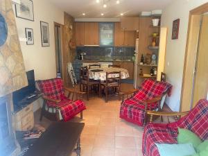 ein Wohnzimmer mit Tisch und Stühlen und eine Küche in der Unterkunft RIERA BAIXOS in Tamariu