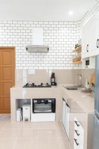 cocina blanca con fogones en Villa Baloo Samui, en Ban Tai
