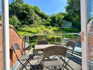 a patio with a table and chairs on a balcony at Laurel Cottage Sandsend in Sandsend