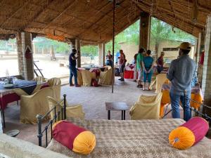 een groep mensen die aan tafels in een tent staan bij Umaid Desert Camp, Raisar in Bikaner