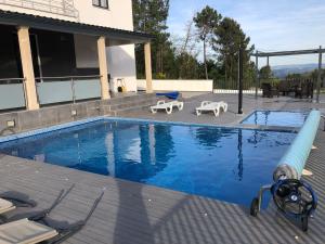 雷阿爾城的住宿－Moradia Activ Mar\Vão，一个带两把草坪椅的游泳池和一个游泳池