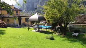 a backyard with a swimming pool and an umbrella at B&B DELL'ANTICA OSTERIA -Varzo in Varzo