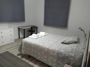 een slaapkamer met een bed, een tafel en een bureau bij A Balea Turquesa in Cangas de Morrazo