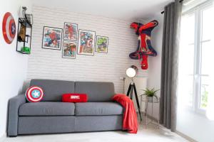 a living room with a gray couch with red pillows at Air-conditioned apartment, walking distance to disney - DISNEY MAGICAL HOMES, PARIS in Serris