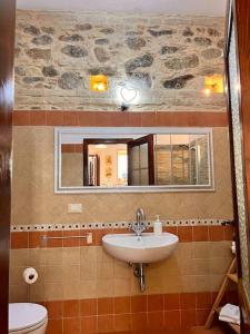 a bathroom with a sink and a toilet and a mirror at Brezza Marina in Scilla