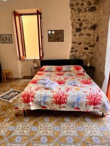 a bedroom with a bed with a colorful comforter at Brezza Marina in Scilla