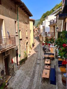 uma rua estreita com mesas e edifícios de madeira em Brezza Marina em Scilla