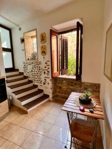 uma sala de estar com uma escada e uma mesa com cadeiras em Brezza Marina em Scilla