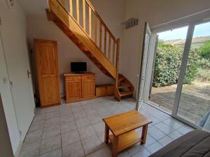 uma sala de estar com uma escada e uma mesa em Charmante maisonnette de vacances em Calvisson