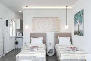 two beds in a room with white walls at Serenita apartments 2 in Agios Nikolaos