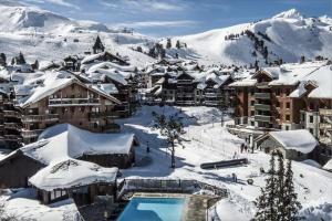 a town covered in snow with a resort at ARC 1950 Appt 6/8 pers LUXE MANOIR SAVOIE - SKI IN SKI OUT in Arc 1950