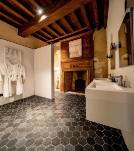 baño con bañera, lavamanos y chimenea en Château de Belet, en Saint-Aquilin